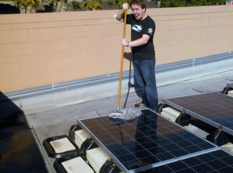 Alex Deeter cleaning a Solar Panel with a mop