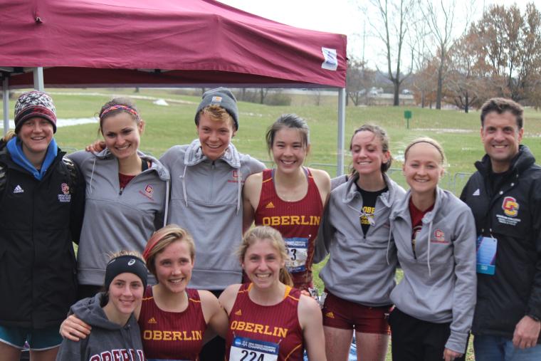 A group of people in running clothes pose for a photo on a field