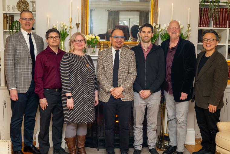 Group of faculty pose with the deans of the college and conservatory indoors.