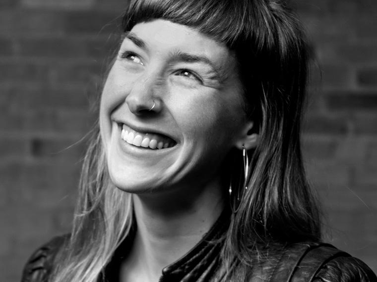 a smiling person looks to the left off camera