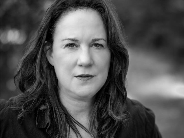 a person with long brown hair wearing a dark jacket