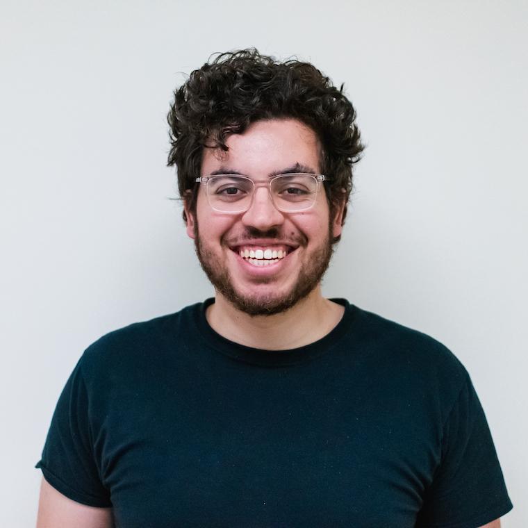 A smiling  León Pescador wearing darak t-shirt.