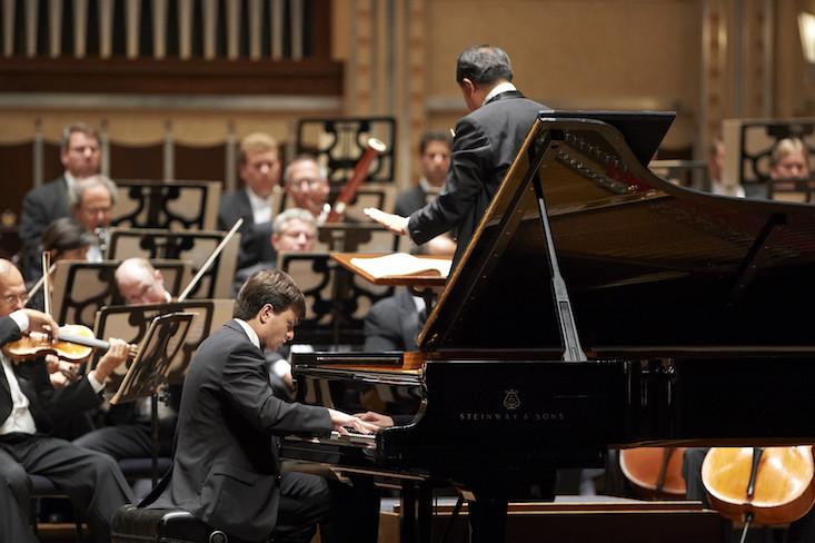 Pianist performs with orchestra.