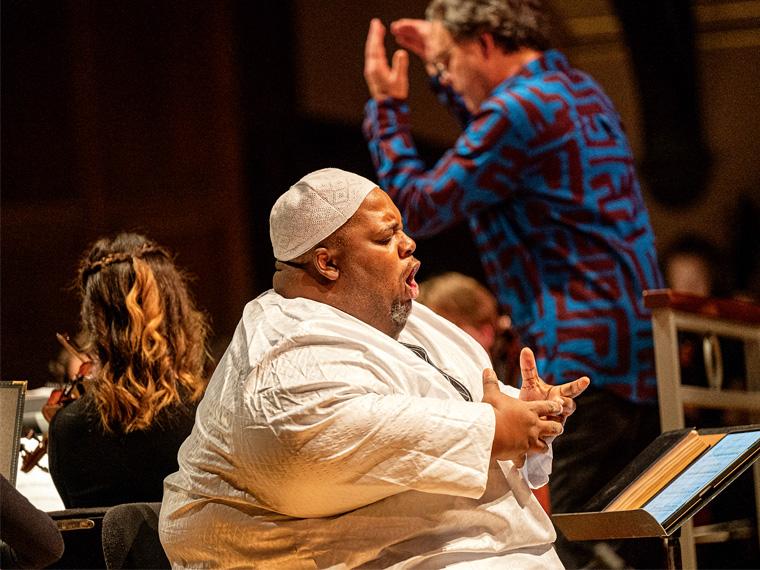 a person wearing a white shirt and cap sings