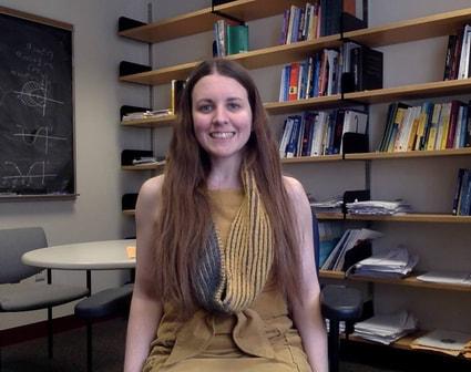 professor seated by a bookshelf