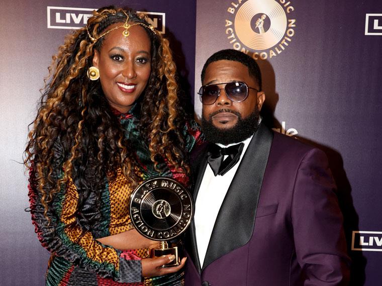 A woman holding an award next to a man in a suit