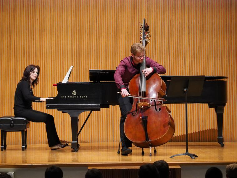 A bassist plays with a bow and is accompanied by a pianist.