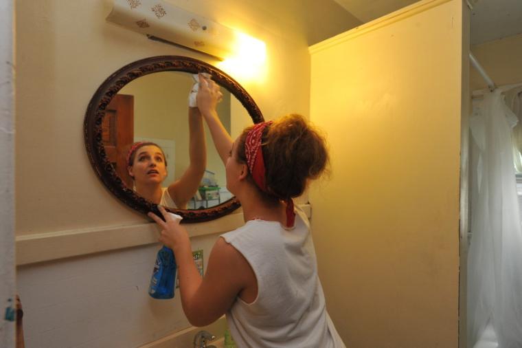A student cleans a mirror.