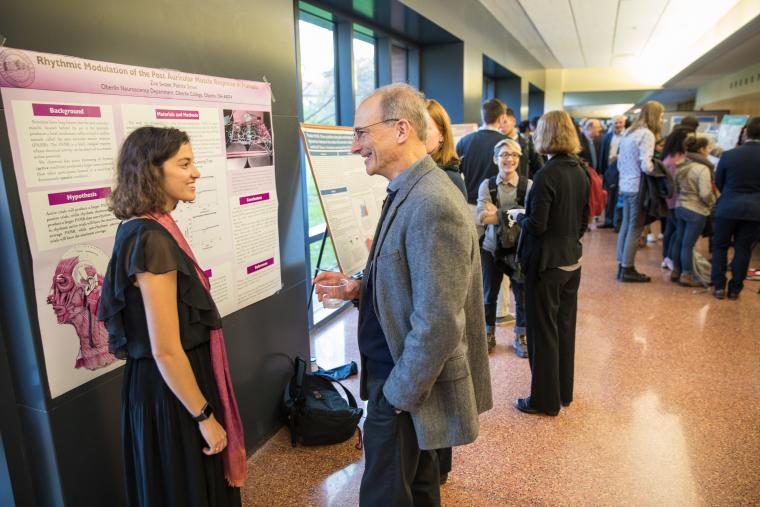 Students present poster board displays in a hallway