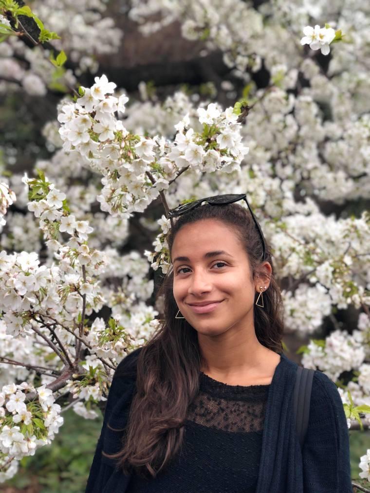 Natalia Garcia smiling in front of a backdrop of flowers