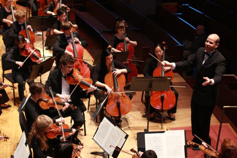 View of orchestra and conductor from behind the stage