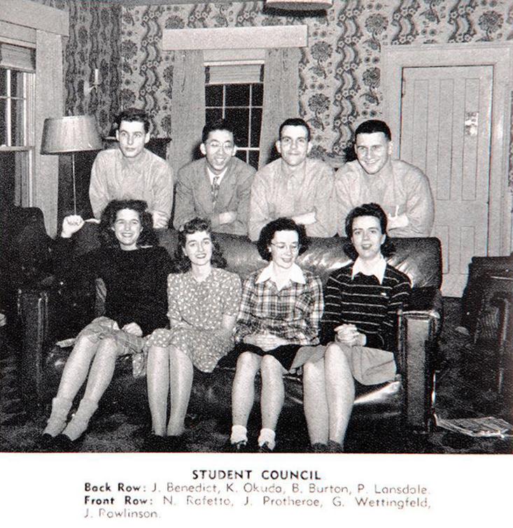 Eight students in a 1940s living room.