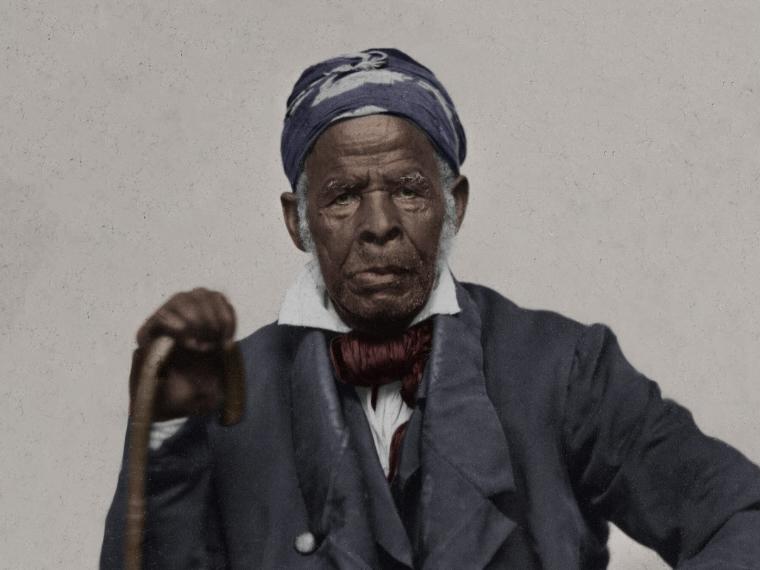 man wearing scarf on head holding a cane