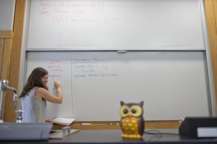 student writing on whiteboard