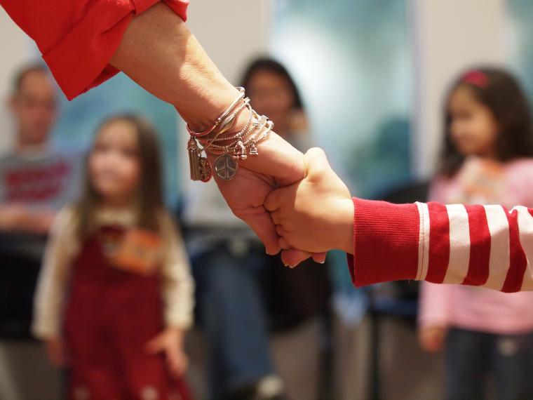 Close-up of adult and child holding hands