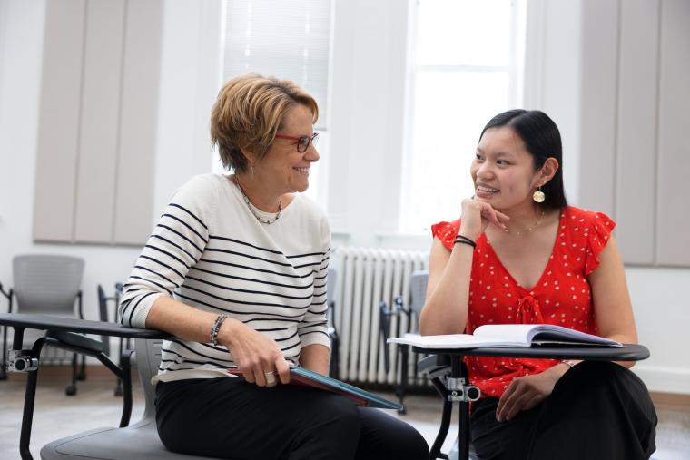 Student and faculty discuss one on one in class room.