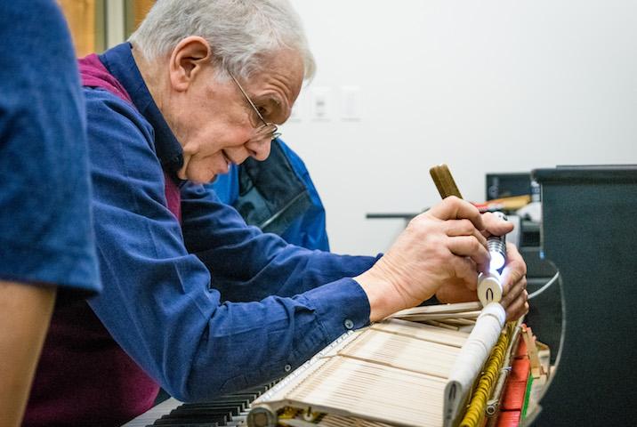 person providing maintenance to a piano 