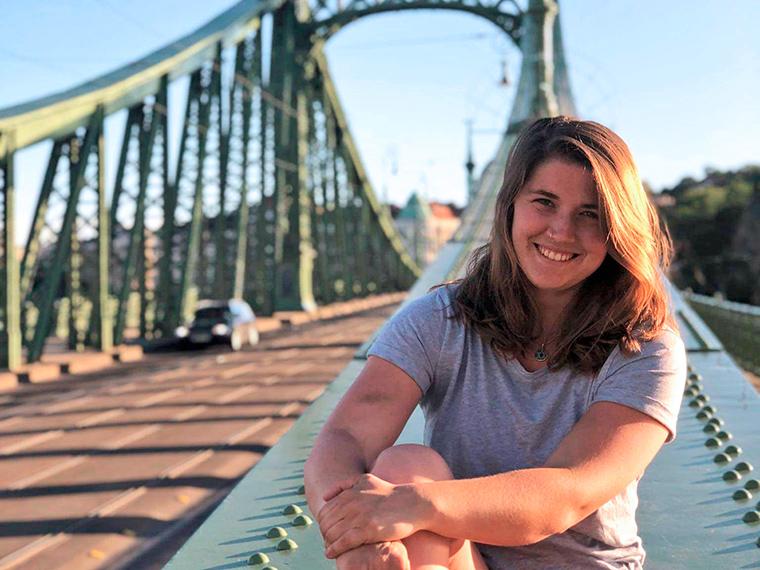 Rainie Heck sitting on a bridge