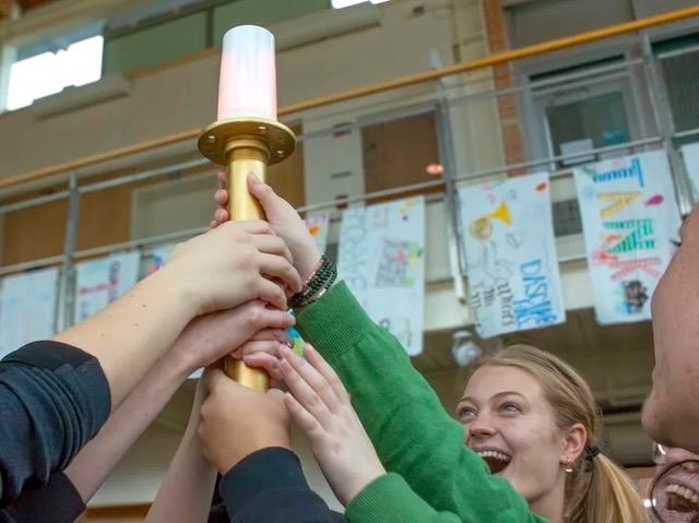 Hands holding a plastic torch in the air.