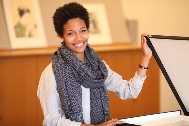 A student holds open the lid of a horizontal display case