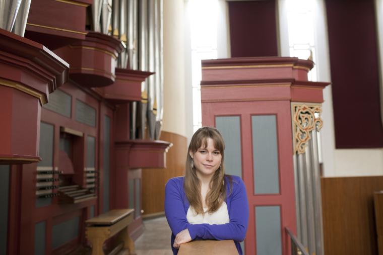 Katelyn Emerson ’15 posing next to an organ loft