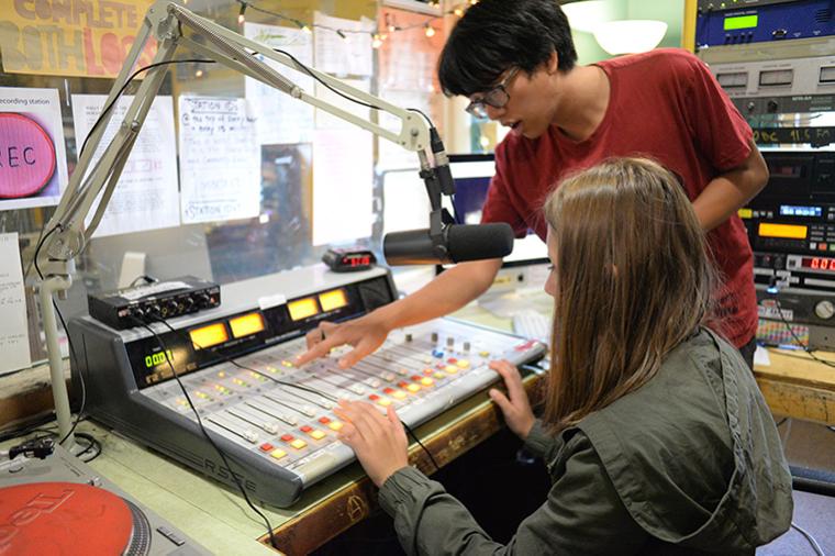 High school students using the soundboard at the WOBC DJ booth