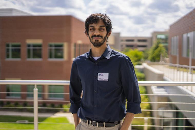 Samir smiling outdoors. Photo.