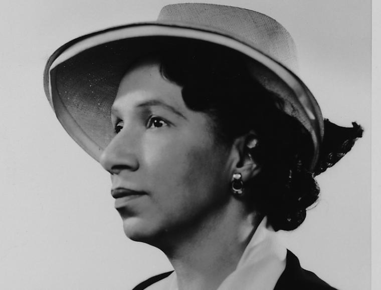 a woman wearing a hat looks to the left