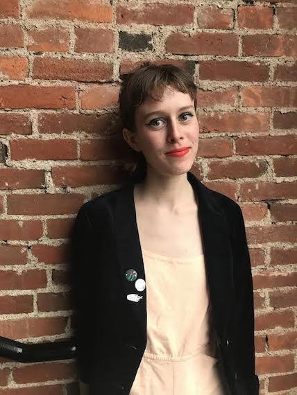 Sophie Kemp standing against a brick wall.