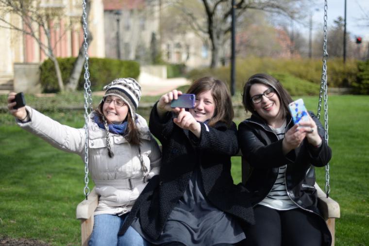 Students sitting on swing next to Finney Chapel.