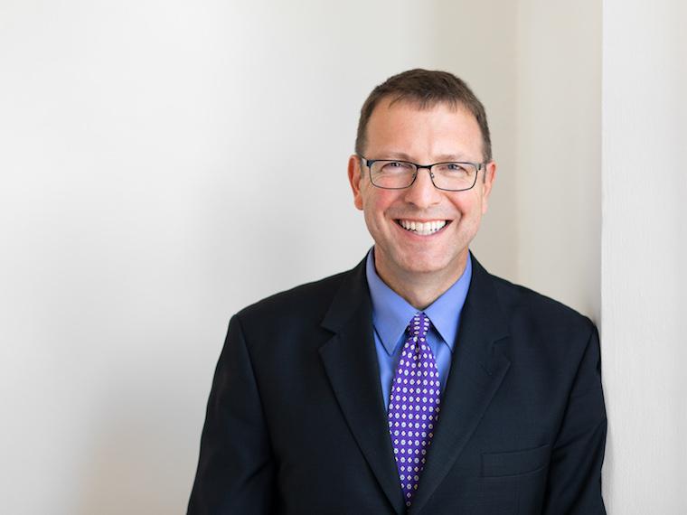 Profile image of man wearing navy blue sport coat, blue shirt, and purple tie