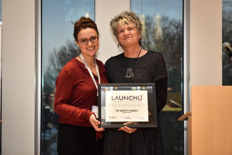 Winner receiving a framed certificate