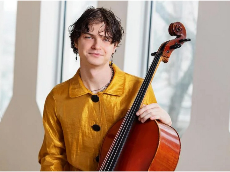 man holding cello and looking at camera
