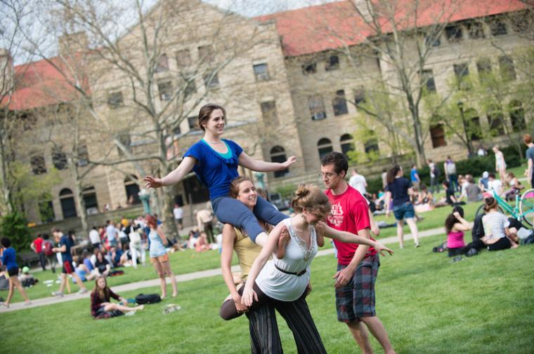 Wilder Bowl filled with people. Acrobats start to climb on top of each other.