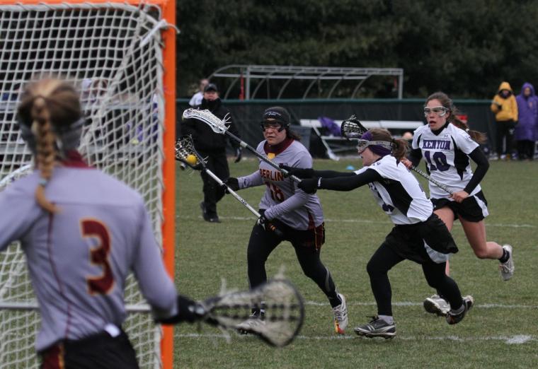 Oberlin womens lacrosse player running towards the opposing net against the Kenyon team