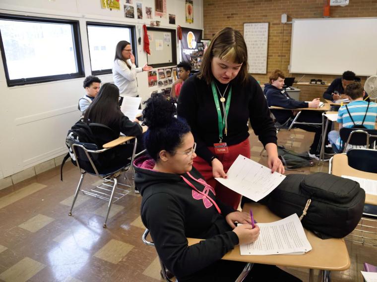 writing tutor assisting high school student 