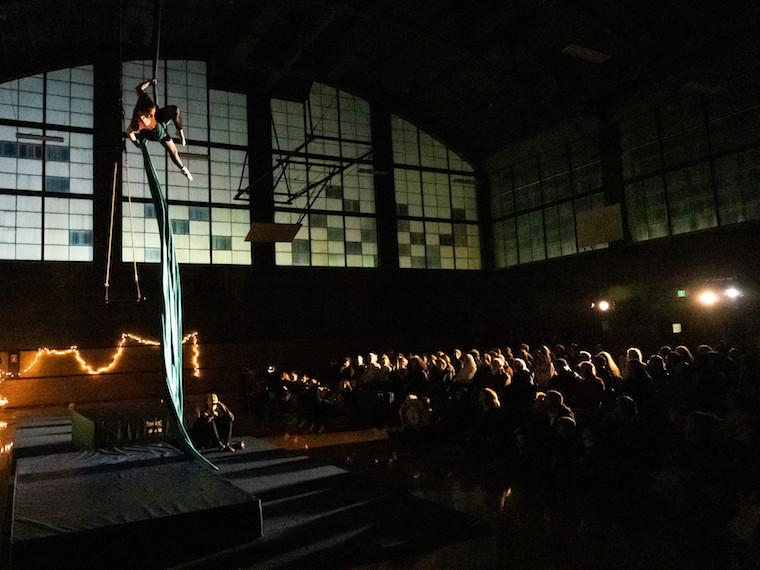 A person climbs up a material rope in a large building.