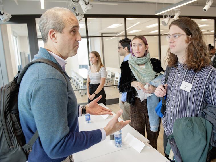 Students stand in line to ask questions after a workshop.