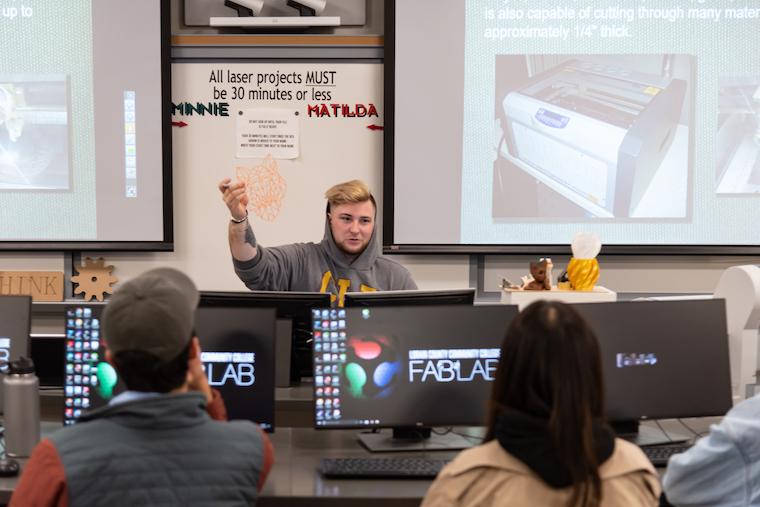 Students sit at computers.