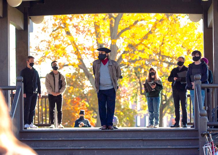 A man stands in front of a group of singers.