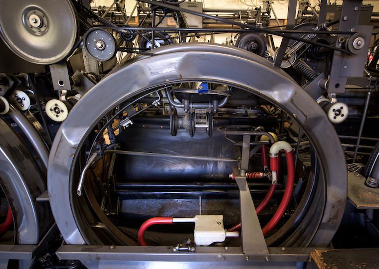 A large round metal piece of equipment surrounded by small gears