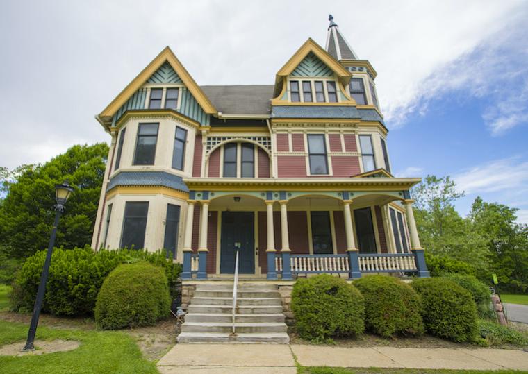 A Victorian style home with wooden porch and stone steps