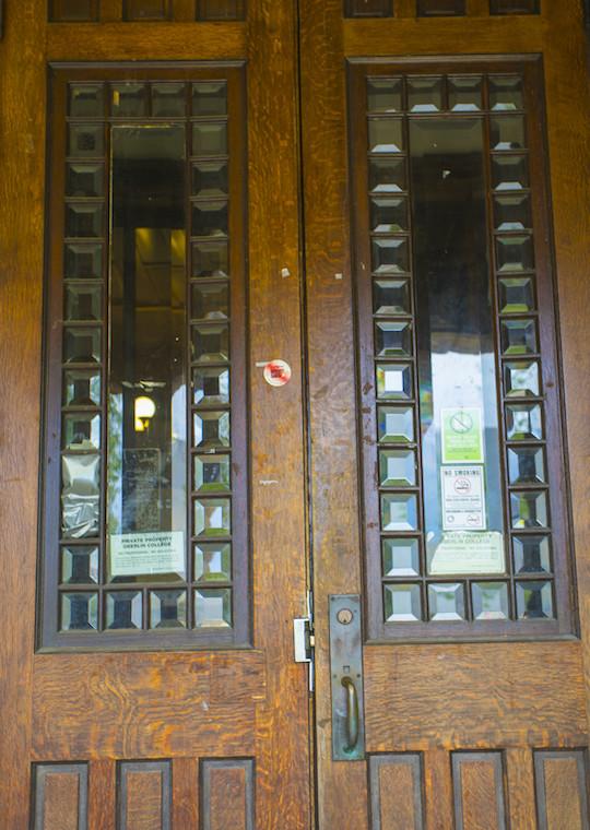A set of slender wooden doors surrounded by tall insets of glass