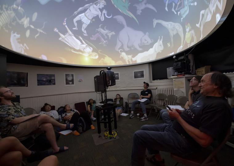 Students look at a astrological symbols in an astronomy class.