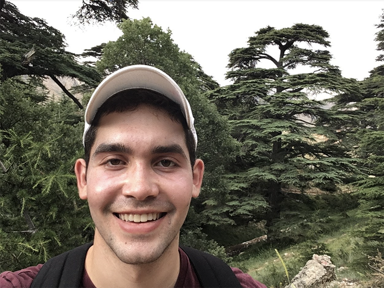 Man standing in front of trees.