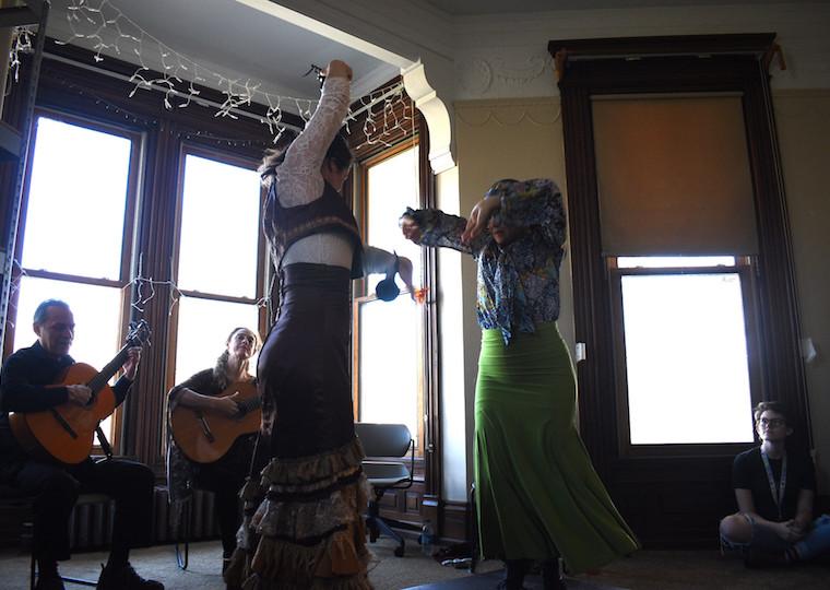 Two women dance in front of a window.