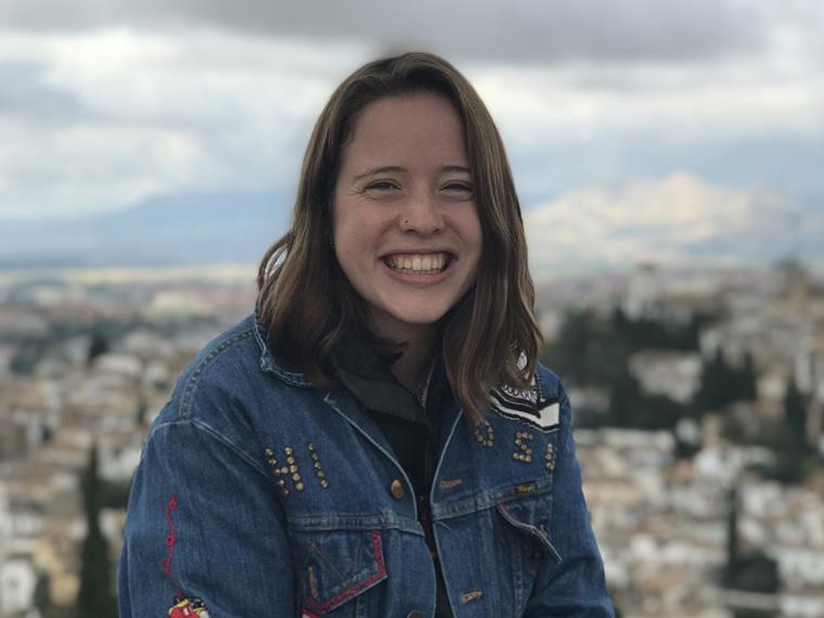 headshot of Nina Harris smiling with city in background.