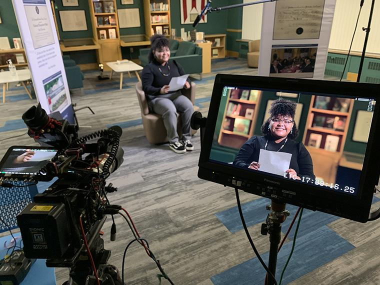 Iesha-LaShay Phillips sits in front of a TV camera.