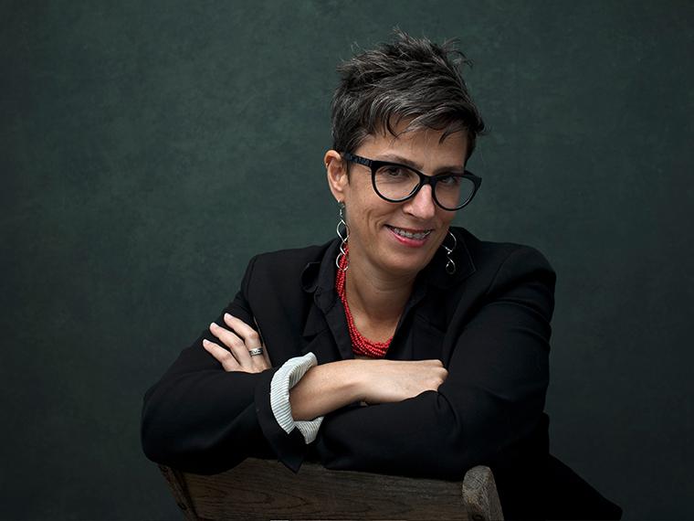 Woman smiling with arms crossed.