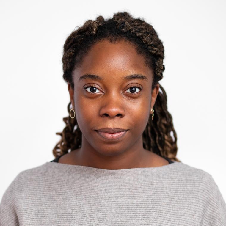 Black woman smiling with white background.